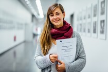 Noemi Rook holding a piece of paper that reads 'The Poster Prize 2017'