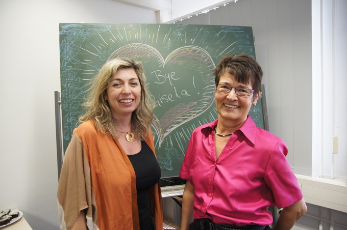 Analia Esponiza and Gisela Stephan standing in front of a blackboard upon which there is a heart with the message 'Goodbye Gisela'