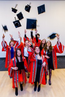 A collection of graduates throwing their hats into the air