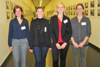 Four women with name badges standing in a corridor