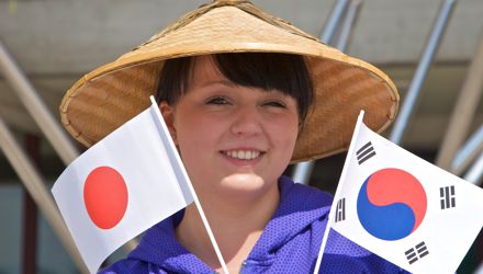 Studentin mit asiatischem Hut und Fähnchen