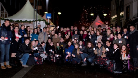 Internationale Studierende vor den RUB Weihnachtsstand