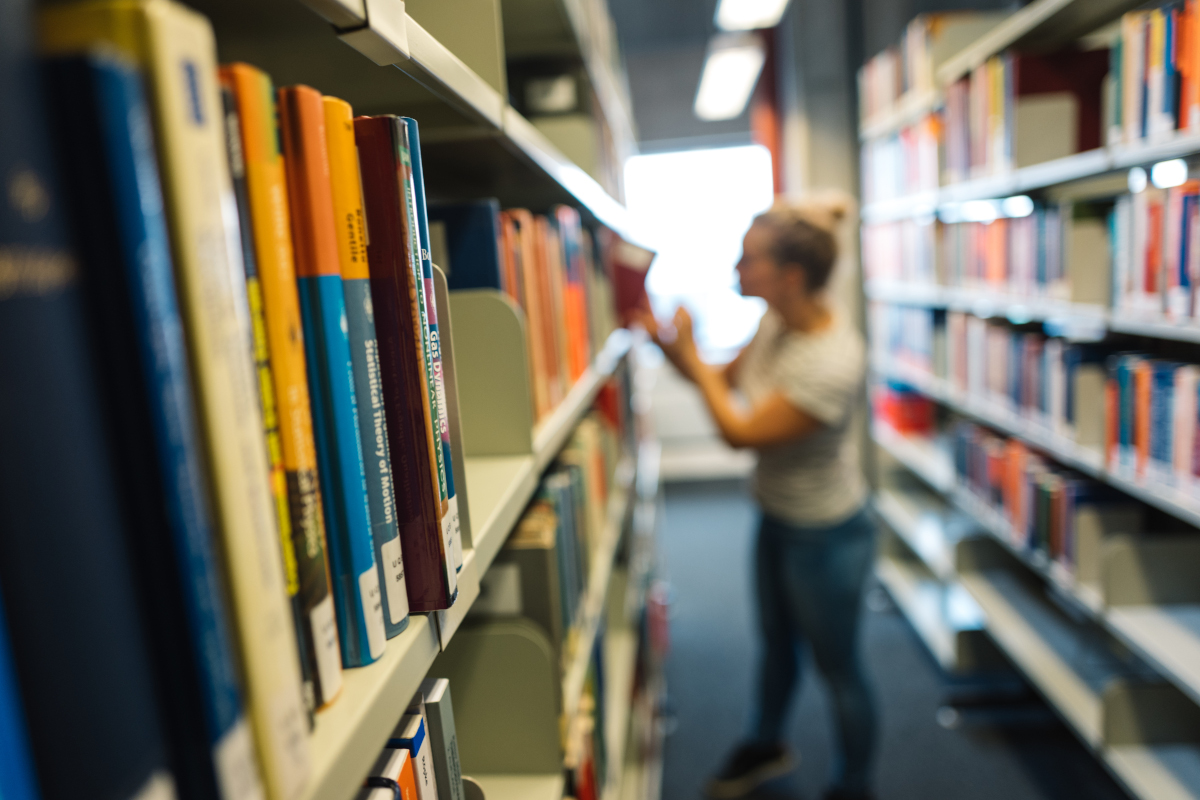 Frau am Bücherregal