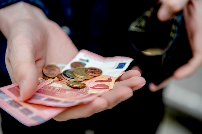 Geldscheine und Münzen in Hand