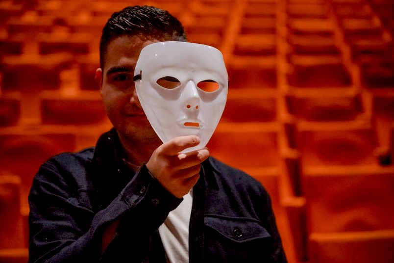 Schauspieler mit weißer Maske, halb vor dem Gesicht