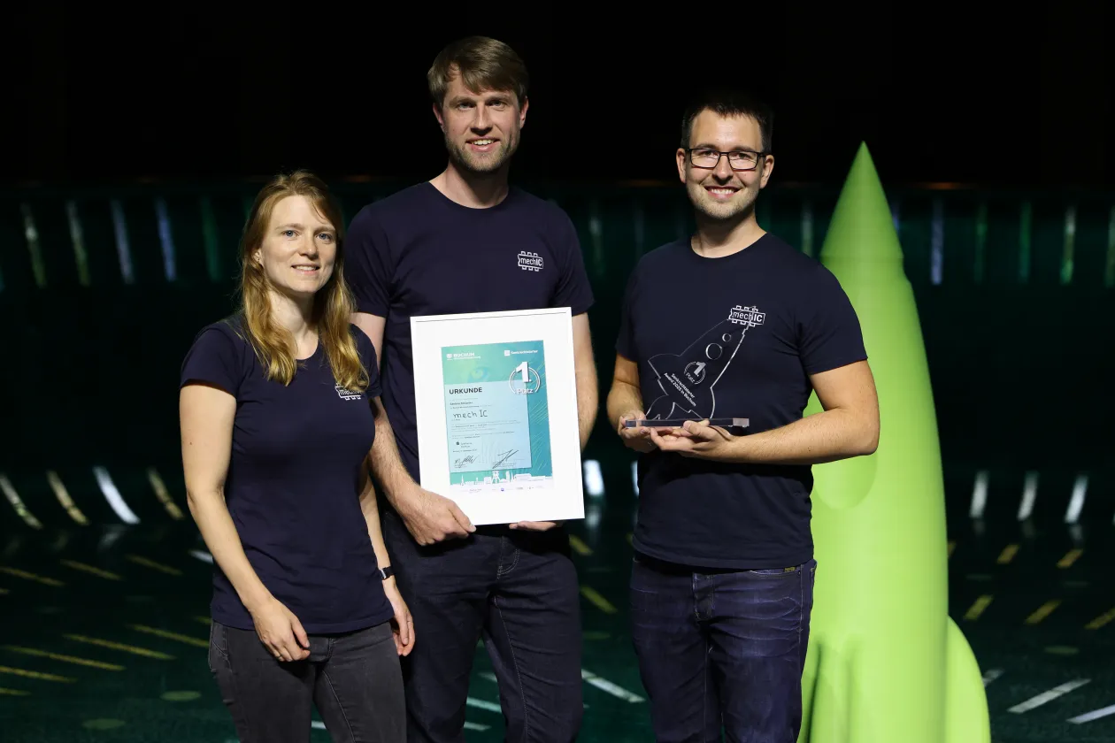 Gruppenbild: 3 Personen mit Urkunde
