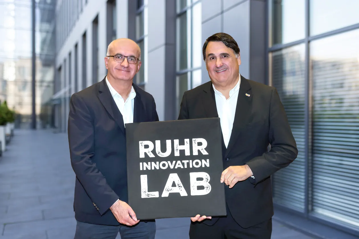 Die Rektoren Bayer und Paul mit einem Schild, auf dem Ruhr Innovation Lab steht
