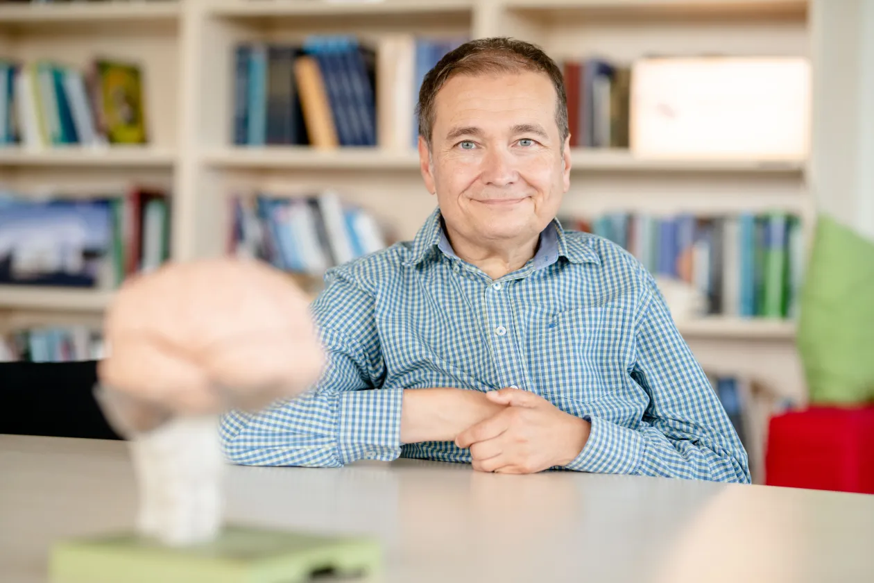 Ein Mann im karierten Hemd sitzt hinter einem Gehirnmodell