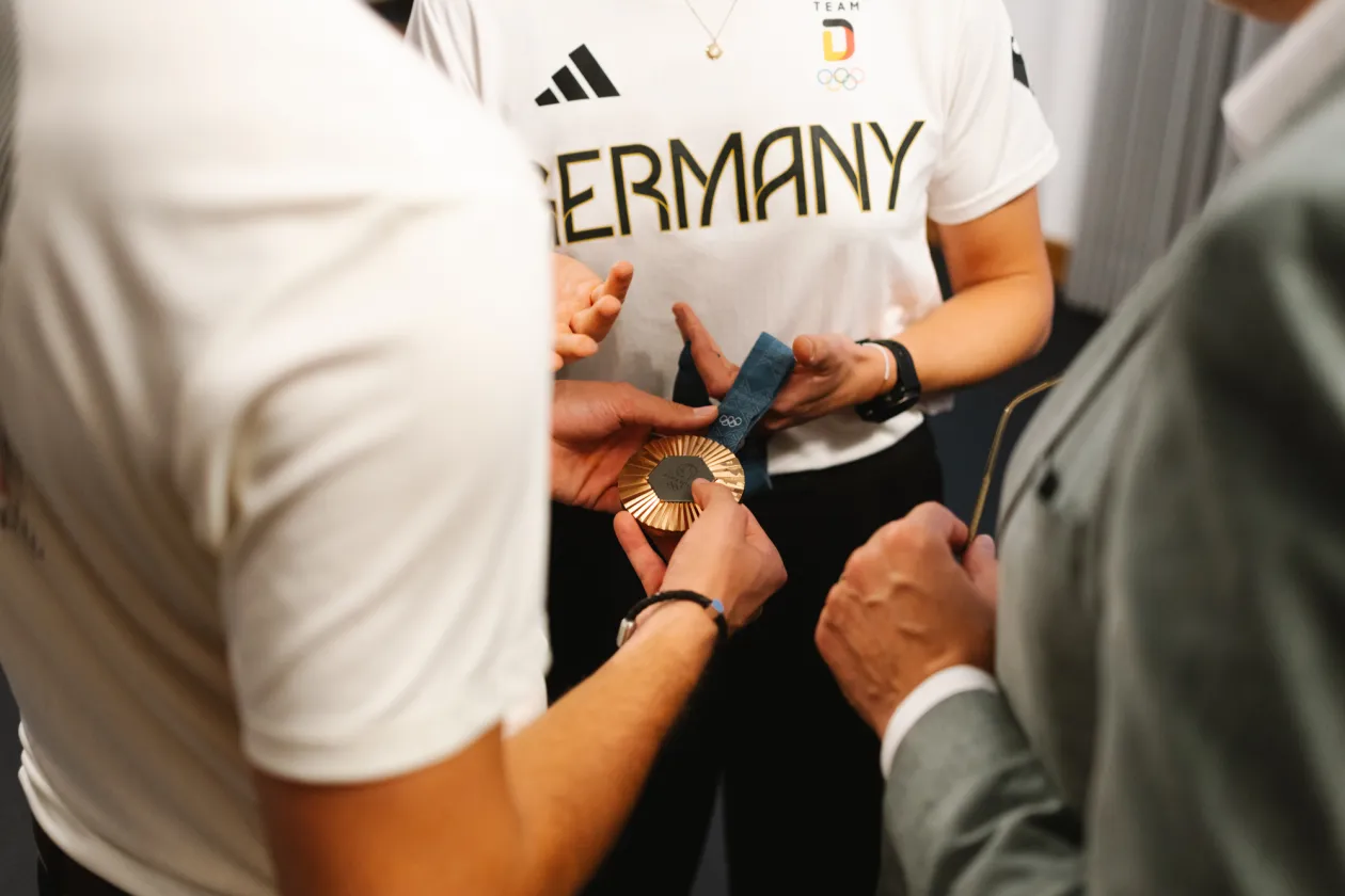 Hände halten eine olympische Medaille