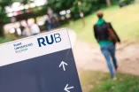 Eine Person läuft in Richtung eines Wegweisers.