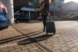 Frau zieht Rollkoffer
