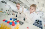 Studentin und Student in weißen Kitteln im Labor