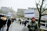 Mann hält Schild hoch