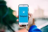 Handy, auf Display steht Telegram