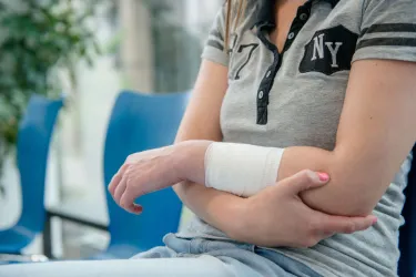 Frau mit Unterarm in Verband