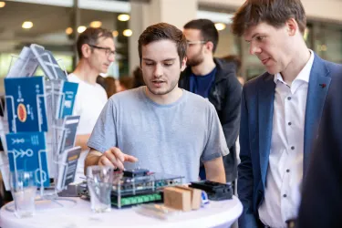 Männer an einem Messestand