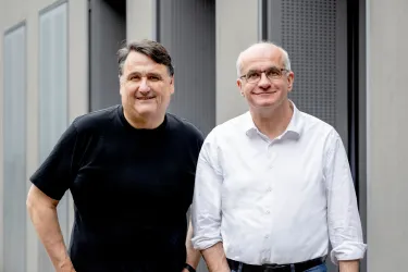 Zwei Männer, einer im weißen, einer im schwarzen Hemd