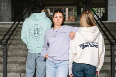 Drei junge Menschen präsentieren Kleidung