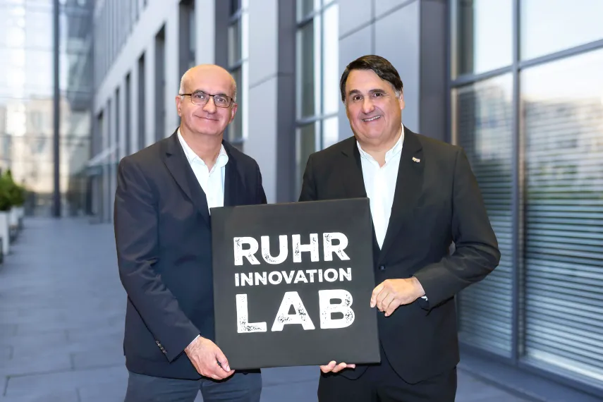 Die Rektoren Bayer und Paul mit einem Schild, auf dem Ruhr Innovation Lab steht